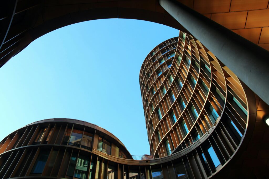 pexels-photo-417273-417273 Innovative modern architecture showcasing curved glass structures against a clear blue sky.
