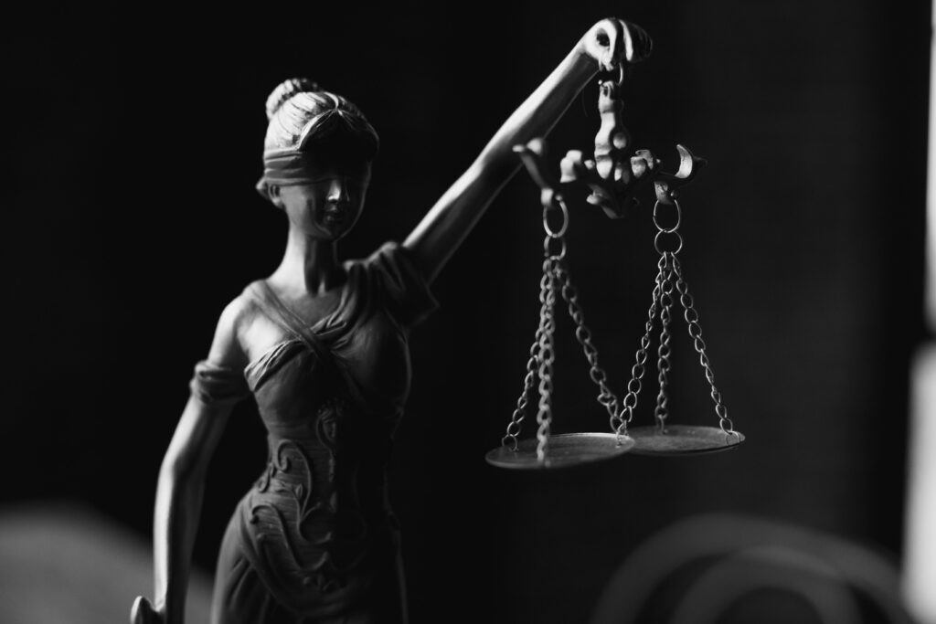 pexels-photo-6077181-6077181 A close-up black and white photo of the Lady Justice figurine with scales.