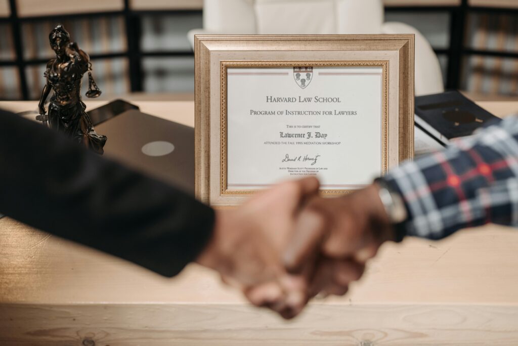pexels-photo-8112119-8112119 Harvard Law School degree with handshake representing achievement and professional agreement.