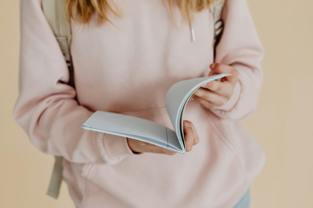 pexels-photo-8147364-8147364 Close-up of a teenager holding a notebook, symbolizing back-to-school season.